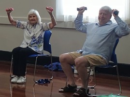 two people sat in chairs exercising