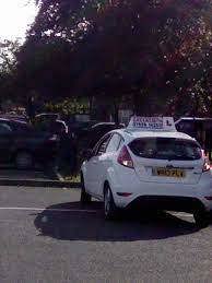 White car with a learner driver sign on top