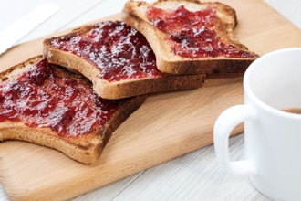 3 slices of toast and jam and a white mug